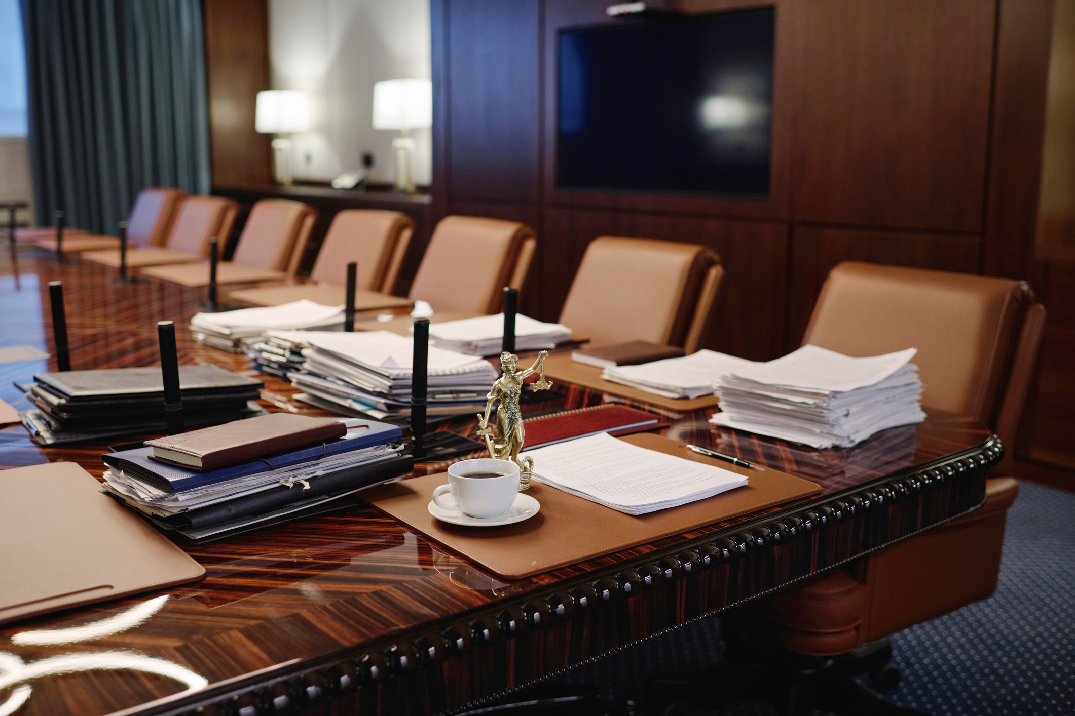 empty boardroom with legal paperwork and lady justice statue