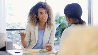 Confident female counselor gestures while giving good advice to female patient