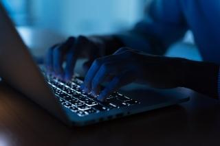 Close up programmer man hand typing on keyboard laptop for register data system