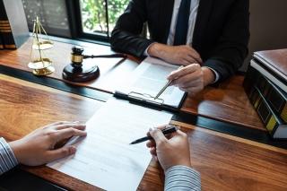 Professional male lawyer or counselor discussing negotiation legal case with client meeting with document contract in office