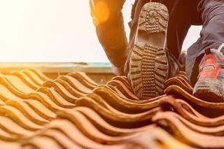 Person climbing along roof on a hot day