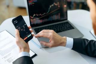 man smartphone laptop stock market down