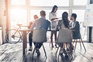Image of office workers around a conference table.