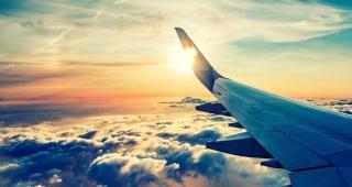 Commercial airplane flying above the clouds as sun sets