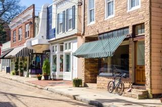 Bike leaning on storefront along cobblestone street