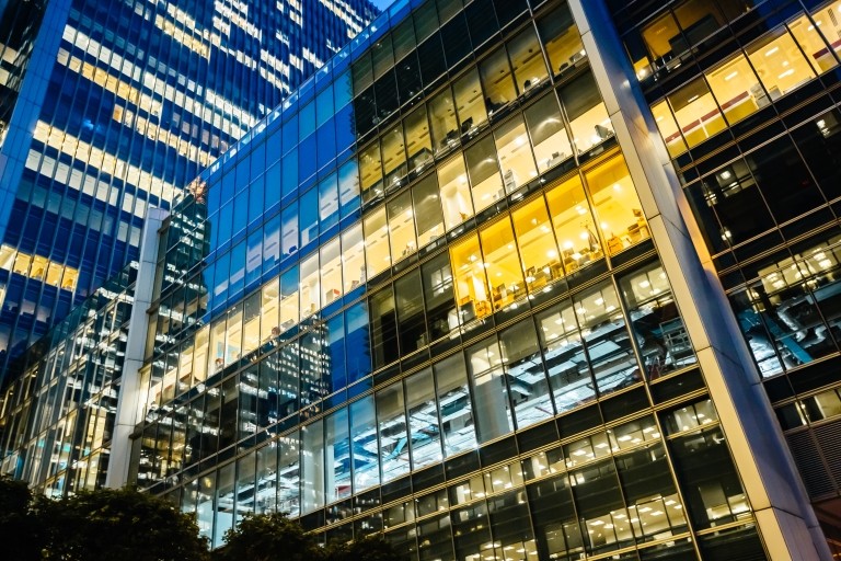 Nighttime view of sleek skyscrapers in the city, glowing with lights