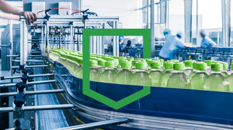 Man working on production line with green bottles in factory