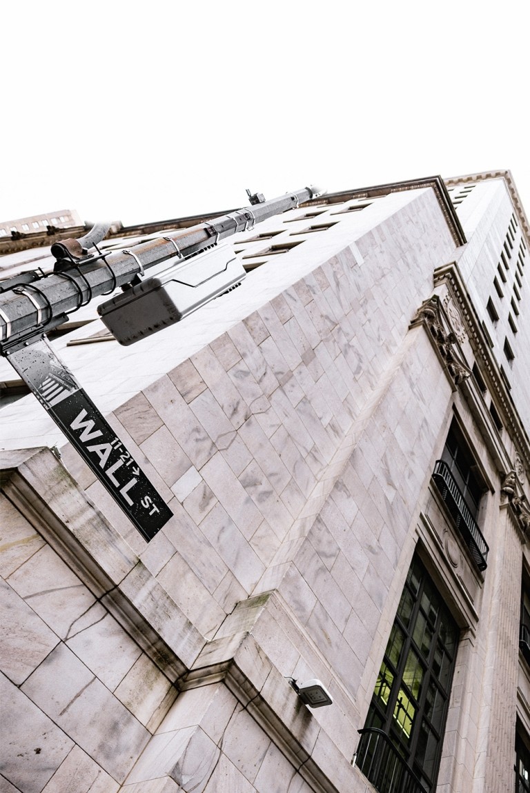 A street sign on a building indicating wall street