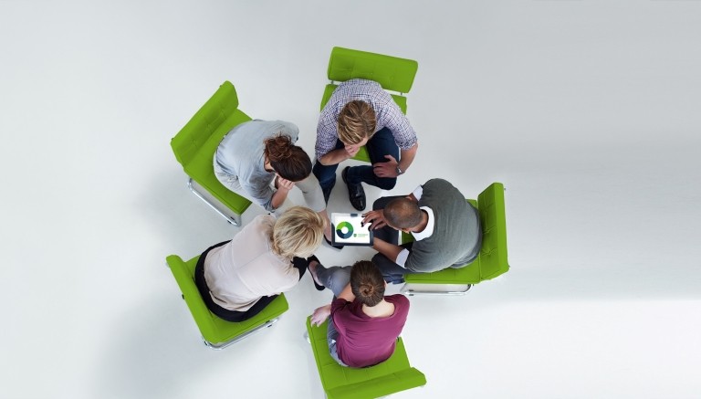 Group gathered in circle discussing charts