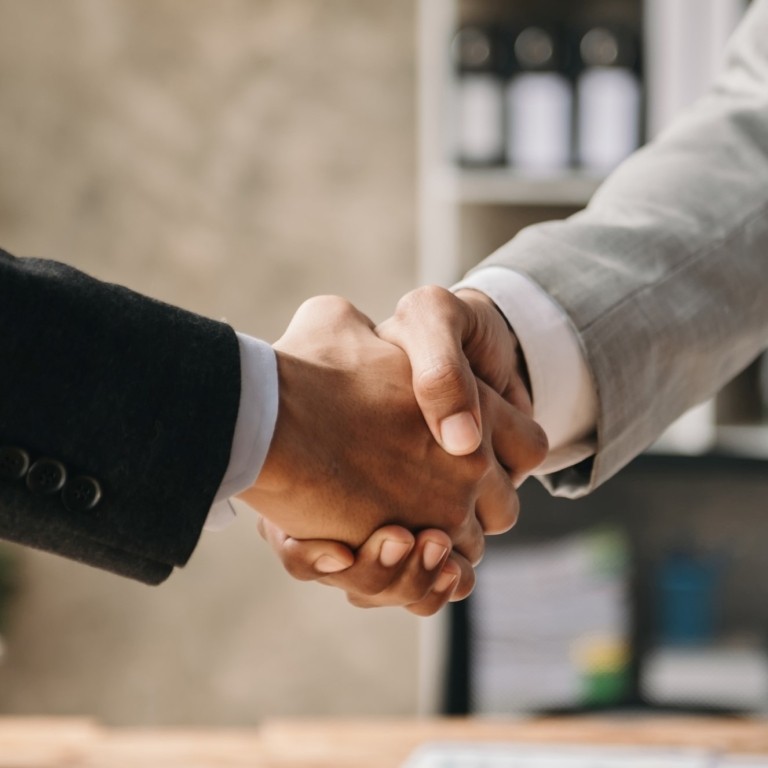 Two confident business man shaking hands during a meeting in the office