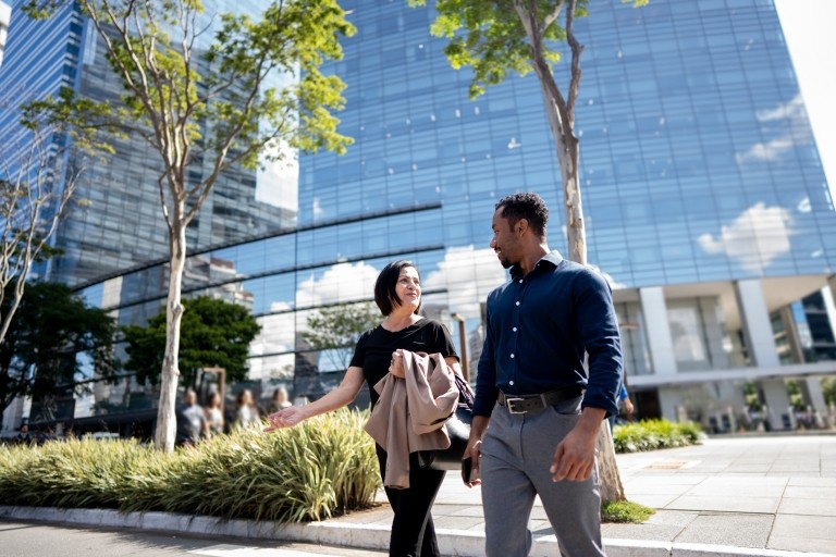 General view of people walking. Park and skyscrapers in background