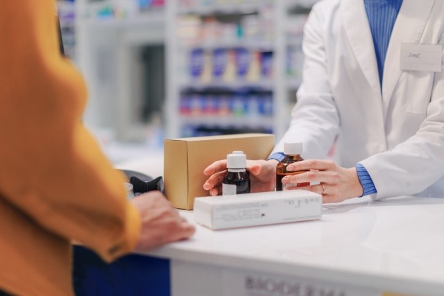 Close up of pharmacist selling medications to the customer