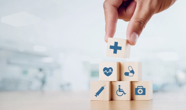 Healthcare icon blocks being stacked into a pyramid