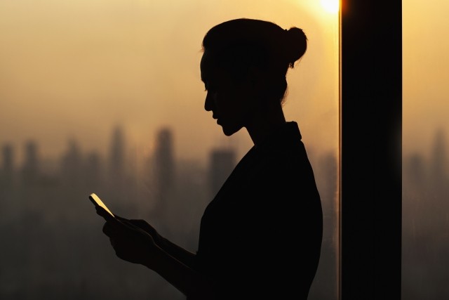 woman on phone against a skyline backdrop