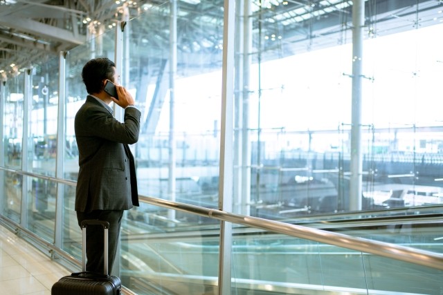 A man in a suit talking on a cell phone at an airport