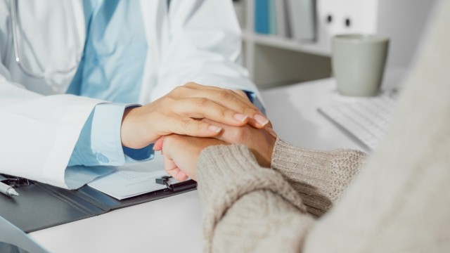 doctor and patient holding hands