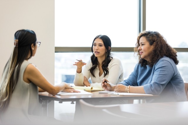 Two female business partners interview mid adult woman