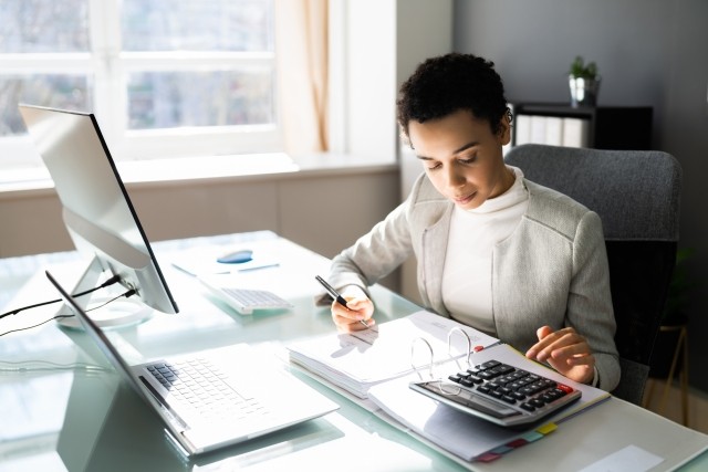 woman looking at healthcare papers and calculator