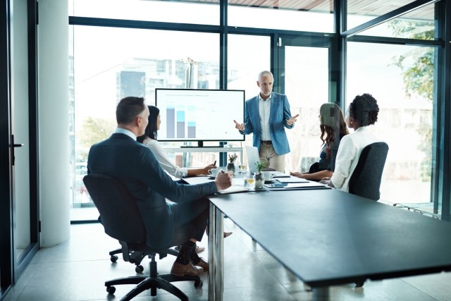 boss talking to his team or group of colleagues in a presentation during board meeting