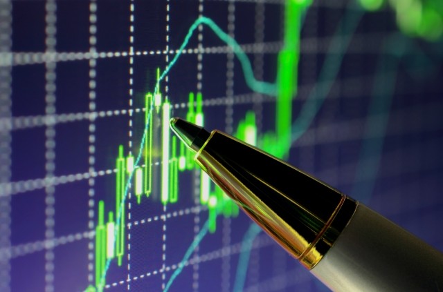 pen pointing at stock market screen