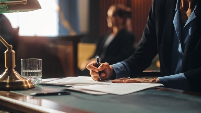 Court of Justice and Law Trial: Female Public Defender Writes Down Arguments for Defense Strategy