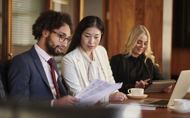 people looking at documents in a conference room