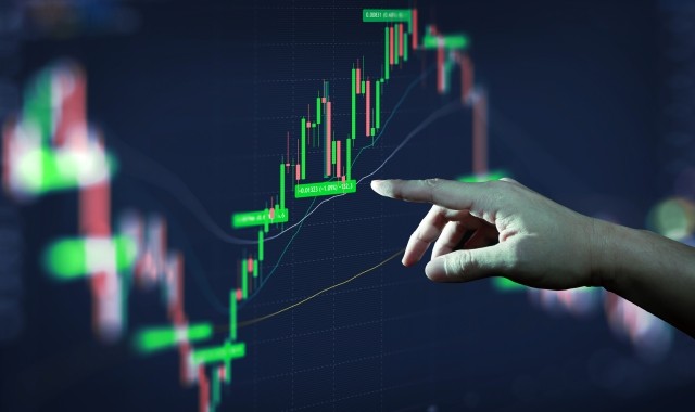 Businessman hand analyzing financial stock market graph on board