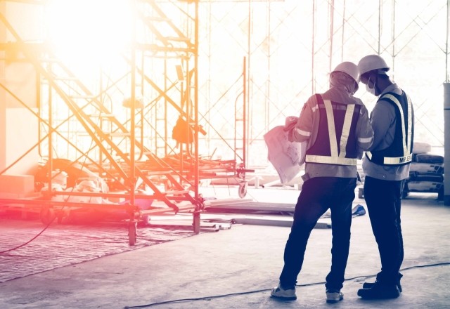 image of a construction site with two contractors reviewing plans