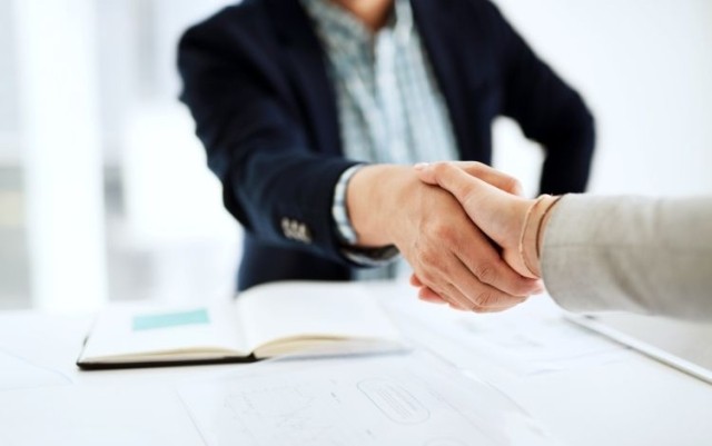 businessman and businesswoman shaking hands in a modern office