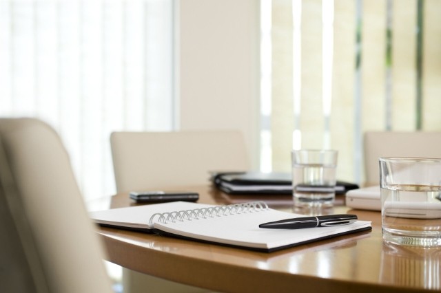Boardroom tabletop with documents and meeting notes