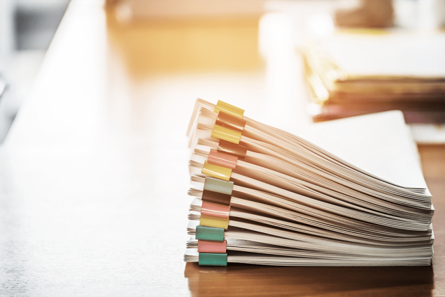 business papers in folders with binder clips