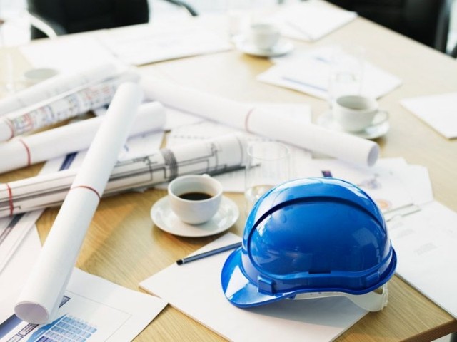Tabletop with construction planning documents and hard hats