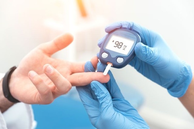 Diabetes patient measuring glucose levels with doctor during workers' comp claim
