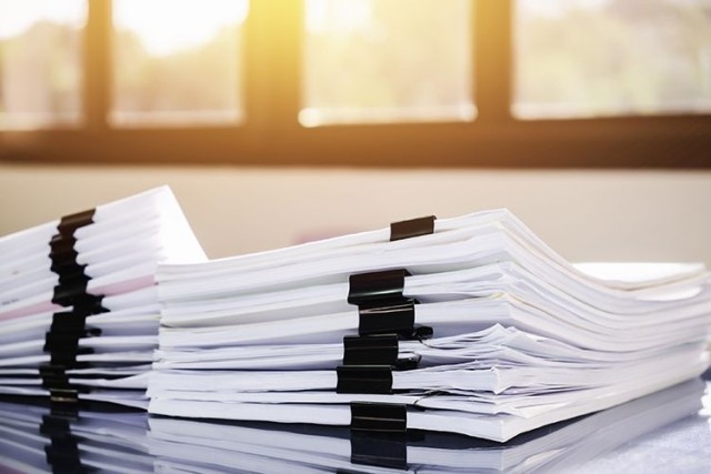Stack of paperwork on table near window