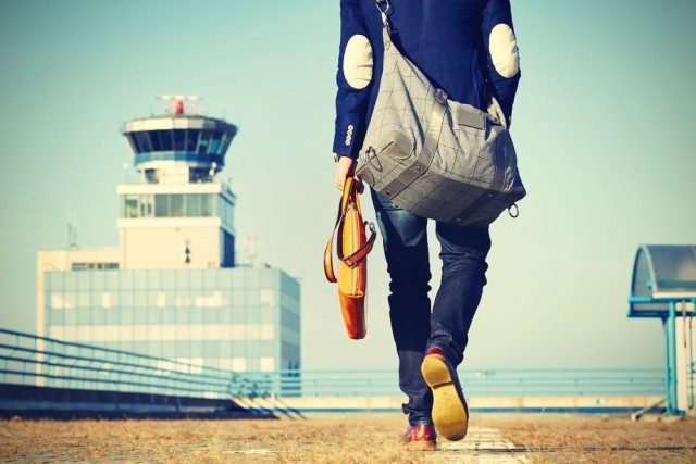 Traveler on an airport tarmac stock photo used by Woodruff Sawyer.