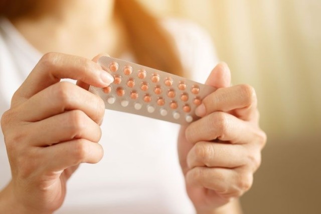 woman holding contraceptive pills