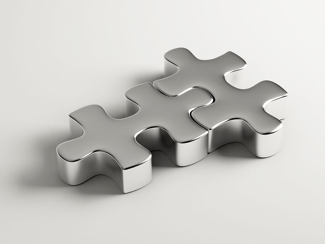 Two metal puzzle pieces fitting together