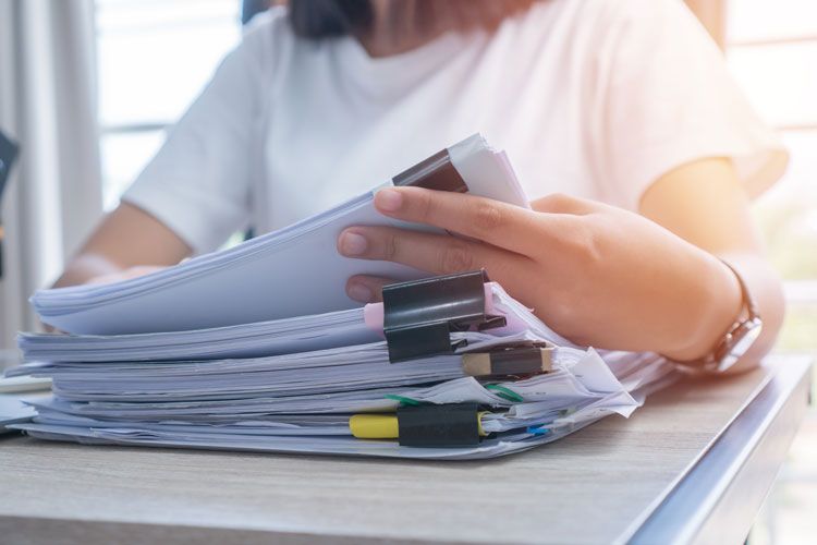 woman reviewing paperwork stack